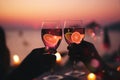 cup of coffee and two glass of wine people silhouette drink orange wine beach cafe at romantic pink sunset evening on sea s Royalty Free Stock Photo