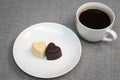 Cup of coffee and two heart-shaped chocolates Royalty Free Stock Photo