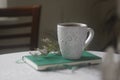 A Cup of coffee on an unusual background with petasls, ornaments and flowers