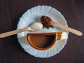 A Cup of coffee with an unusual shape on a white plate and spoons with ground coffee and sugar Royalty Free Stock Photo
