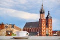 A Cup of coffee with view of Church Bazylika Mariacka or towers of st.Mary`s. Top view from roof or balcony to old Krakow,Poland Royalty Free Stock Photo