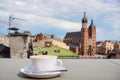 A Cup of coffee with view of Church Bazylika Mariacka or towers of st.Mary`s. Top view from roof or balcony to old Krakow,Poland Royalty Free Stock Photo