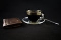 A cup of coffee and a wallet on a dark background