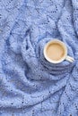 Cup of coffee on warm blue blanket. Winter mood concept. Royalty Free Stock Photo