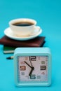 A cup of coffee, a watch, and a notebook on a blue background. The concept of the business theme