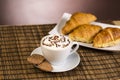 Cup of coffee with whipped cream and croissants Royalty Free Stock Photo