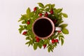 Cup of coffee on a white background in leaves and red berries.F Royalty Free Stock Photo