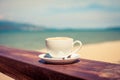 A cup of coffee in a white cup on beach background Royalty Free Stock Photo