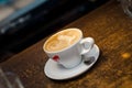 A cup of coffee in a white cup on wooden background