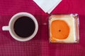 Cup of coffee, a white napkin and a candle on a red background. View from above. Royalty Free Stock Photo