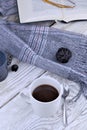 Cup of coffee on white table with scarf and book