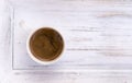 Cup of coffee on white wooden salver