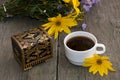 cup of coffee, wild flowers, casket and yellow flower, still life, on a wooden table