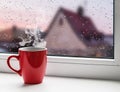Cup of coffee on the windowsill on the background city roofs in Royalty Free Stock Photo