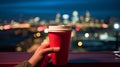 cup of coffee in woman hand street cafe at night ,view on rainy city blurred light and houses