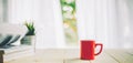 Cup of coffee on wood table top and blur of curtain with window background