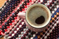 Cup of coffee on wooden background with textile hand-woven rag rug. Copy space, top view