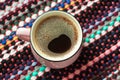 Cup of coffee on wooden background with textile hand-woven rag rug. Copy space, top view Royalty Free Stock Photo