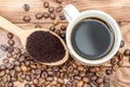Cup of coffee, wooden spoon with ground coffee and coffee beans on the table Royalty Free Stock Photo