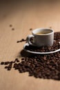 Cup of coffee on a wooden table with coffee beans