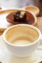 Cup of coffee on wooden table with confectioners atmosphere