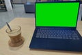 A cup of coffee on wooden table beside laptop Royalty Free Stock Photo