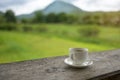 Cup of coffee on a wooden table over mountains landscape and rice field with sunlight. Beauty nature background Royalty Free Stock Photo