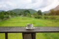 Cup of coffee on a wooden table over mountains landscape and rice field with sunlight. Beauty nature background Royalty Free Stock Photo