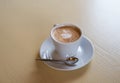 A cup of coffee on a wooden table and a small spoon Royalty Free Stock Photo