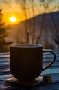 The cup with coffee on the wooden table during the sunset Royalty Free Stock Photo