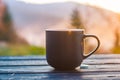 The cup with coffee on the wooden table during the sunset Royalty Free Stock Photo