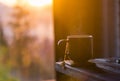 The cup with coffee on the wooden table during the sunset Royalty Free Stock Photo