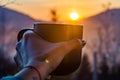 The cup with coffee on the wooden table during the sunset Royalty Free Stock Photo