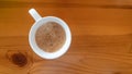 Cup of coffee on wooden table, top view. Coffee break.