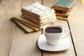 Cup of coffee on wooden table. Vintage books and pile of letters