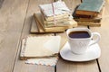 Cup of coffee on wooden table. Vintage books and pile of letters