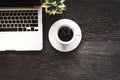 Cup of coffee with work in the laptop,morning on old wooden table.