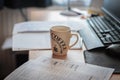 A cup of coffee on a workplace desk. Having a break of working or learning. Infront is standing a compter. It`s coffee time. Royalty Free Stock Photo