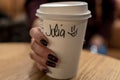 Cup of coffee with writen word JULIA in woman hand Royalty Free Stock Photo