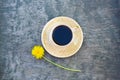 Cup of coffee, yellow dandelion flower on vintage blue wooden background, summer flatlay. Copy space for your text and product.
