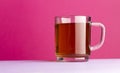 Cup of cold tea on the clean pink background