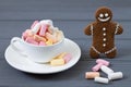 Cup with colored marshmellow and smiling gingerbread man