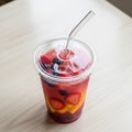 Cup containing a refreshing fruit infused drink sits on a light Royalty Free Stock Photo