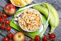 A cup with crackers is standing on the scales. A measuring tape is wound around. Nearby are a bunch of tomatoes, bananas and Royalty Free Stock Photo