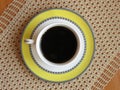 A cup of dark coffee on crochet table cloth and oak wood table background. Top view. Royalty Free Stock Photo