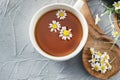 Cup of delicious camomile tea on light table, closeup Royalty Free Stock Photo