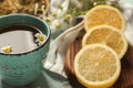 Cup of delicious camomile tea and sliced lemon on table, closeup Royalty Free Stock Photo