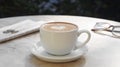 Cup of delicious coffee, glasses and newspaper on beige marble table outdoors Royalty Free Stock Photo