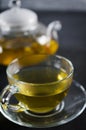 Cup of delicious herbal tea and glass teapot. Royalty Free Stock Photo