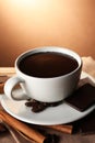 Cup of delicious hot chocolate, spices and coffee beans on wooden table